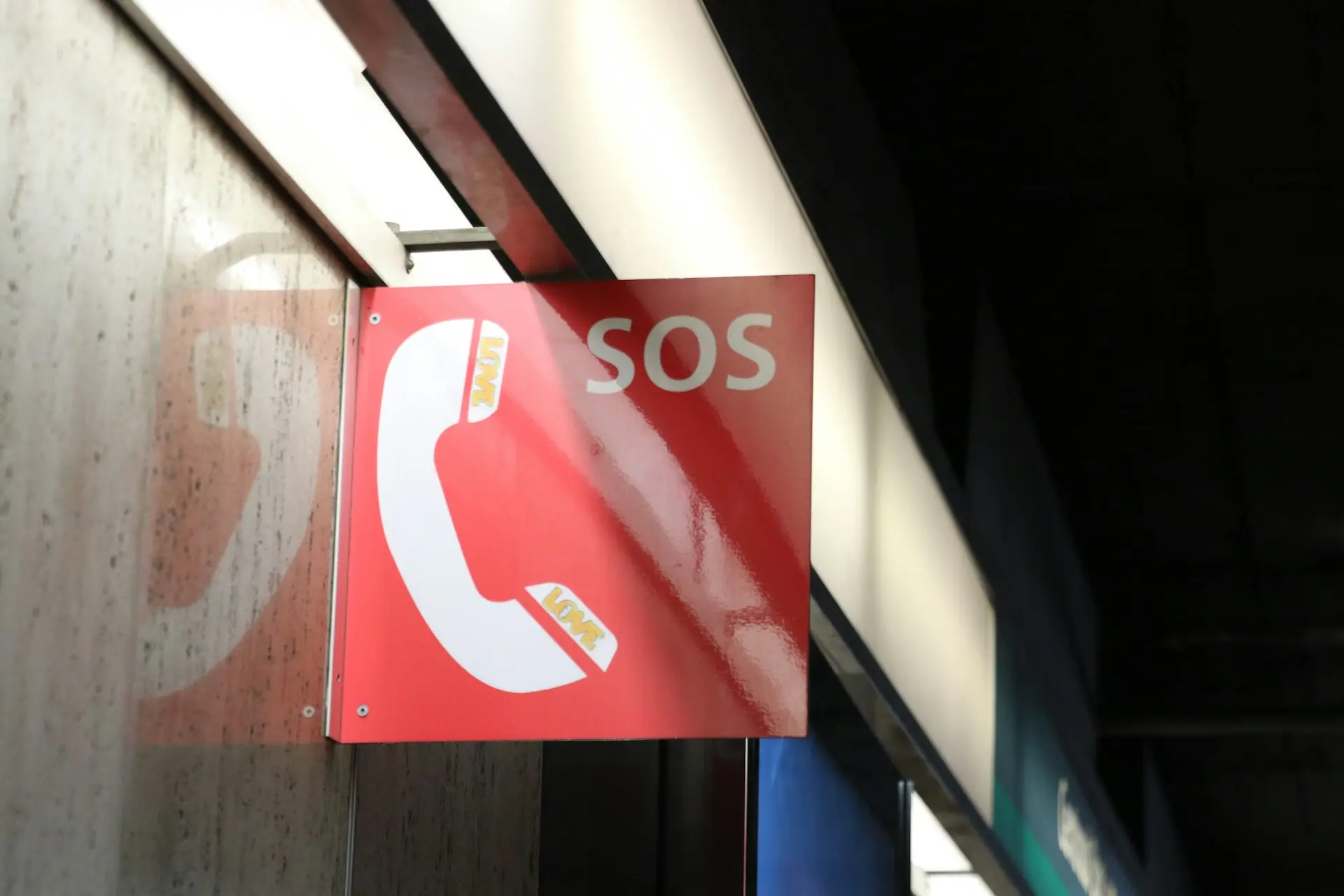 a red sign hanging from the side of a building